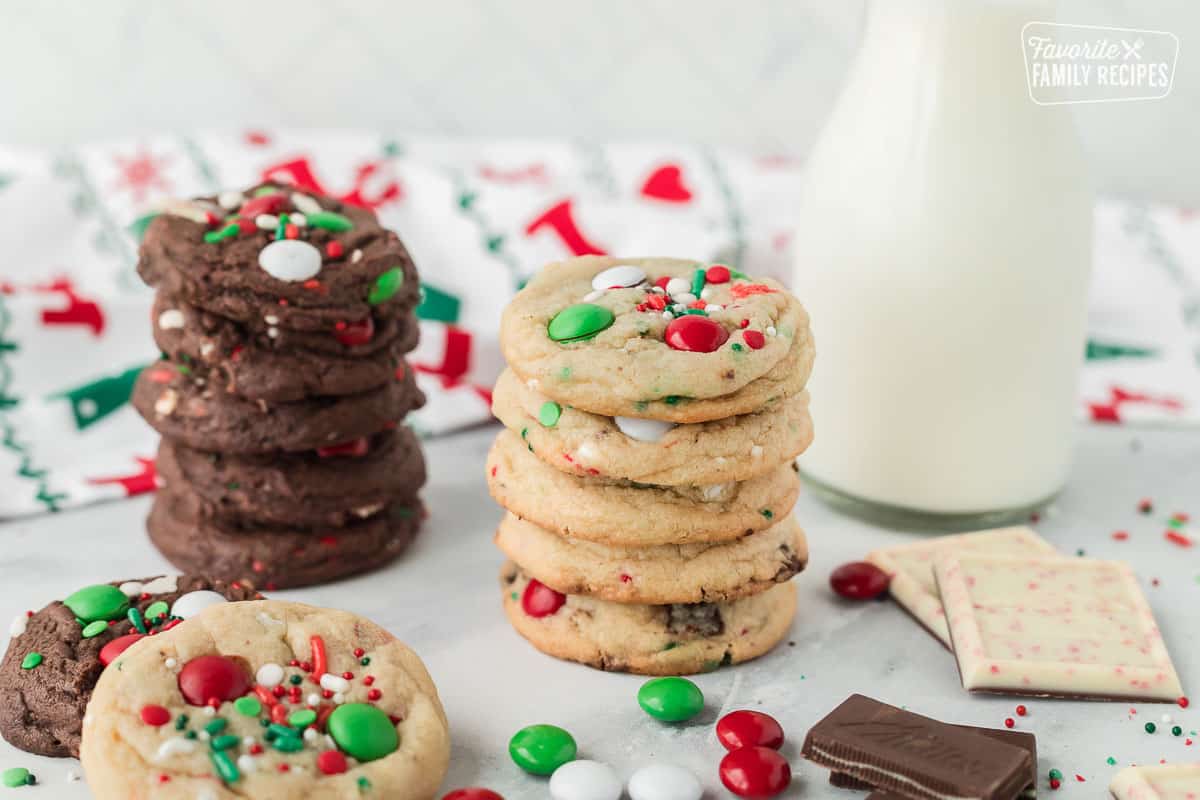 Stacked Elf Cookies next to a tall glass of milk.