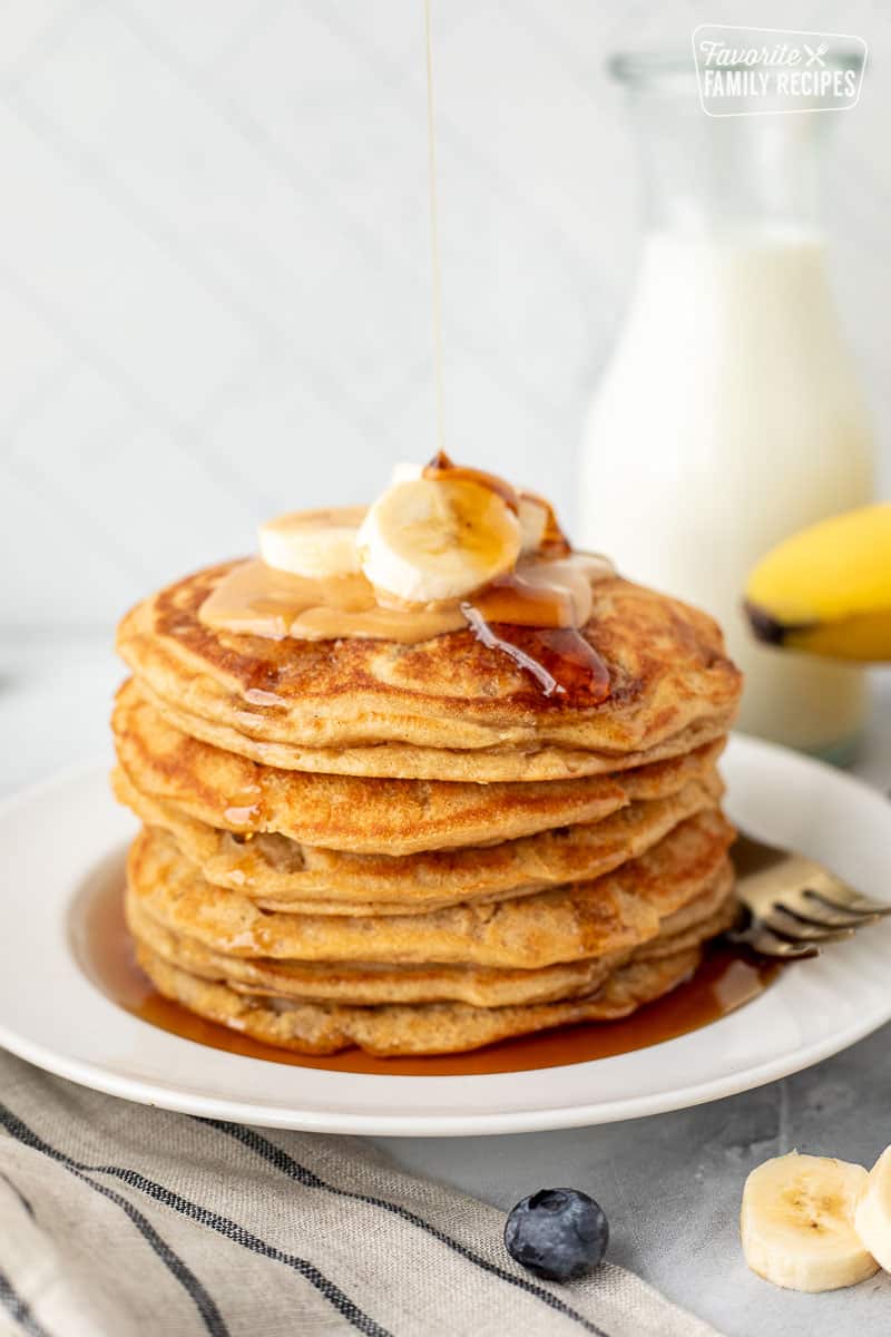 Stack of Peanut Butter Pancakes with maple syrup pouring on top.