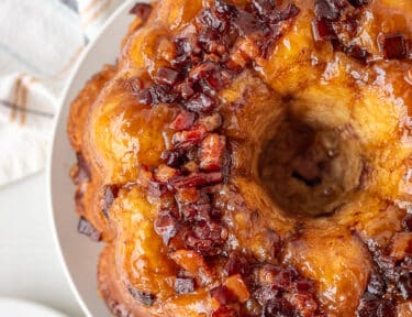 Maple syrup and cut bacon on top of a cinnamon sugar Monkey Bread.