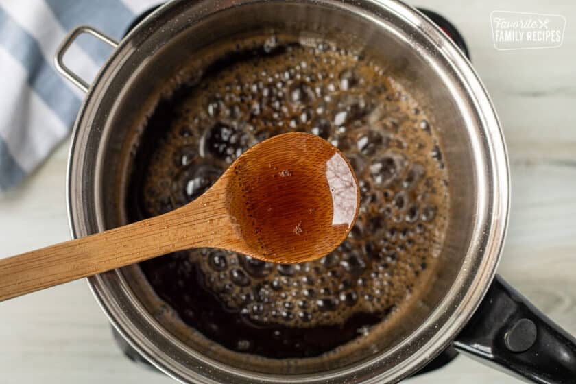 Wooden spoon over a pan pot of boiling Maple Syrup.