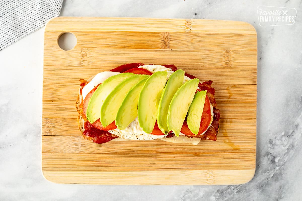 Eggs, tomato and avocado on top of bacon.