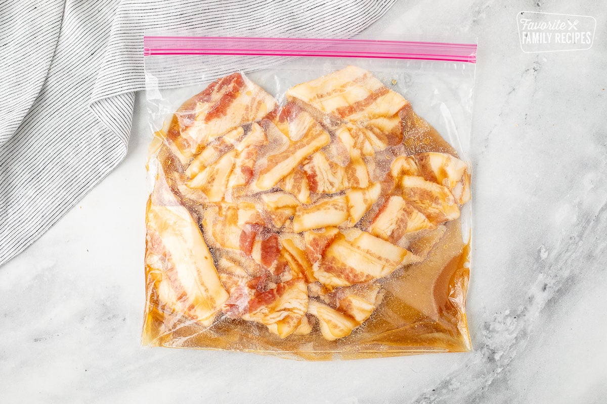 Bag with sliced bacon marinating in syrup and brown sugar mixture.