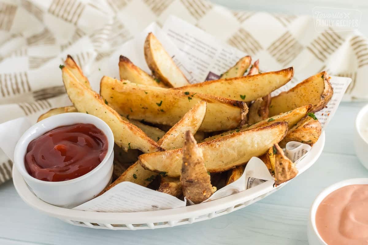 Baked potato wedges in a fry basket with ketchup