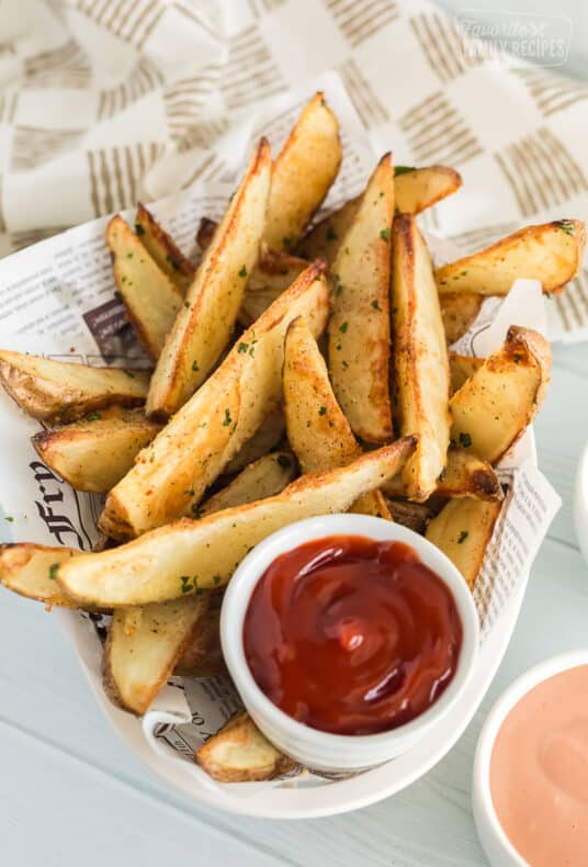 Baked potato wedges in a fry basket with ketchup