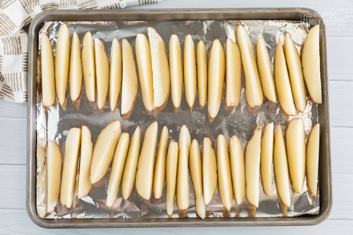 Wedges of potatoes laid out onto a cookie sheet with foil