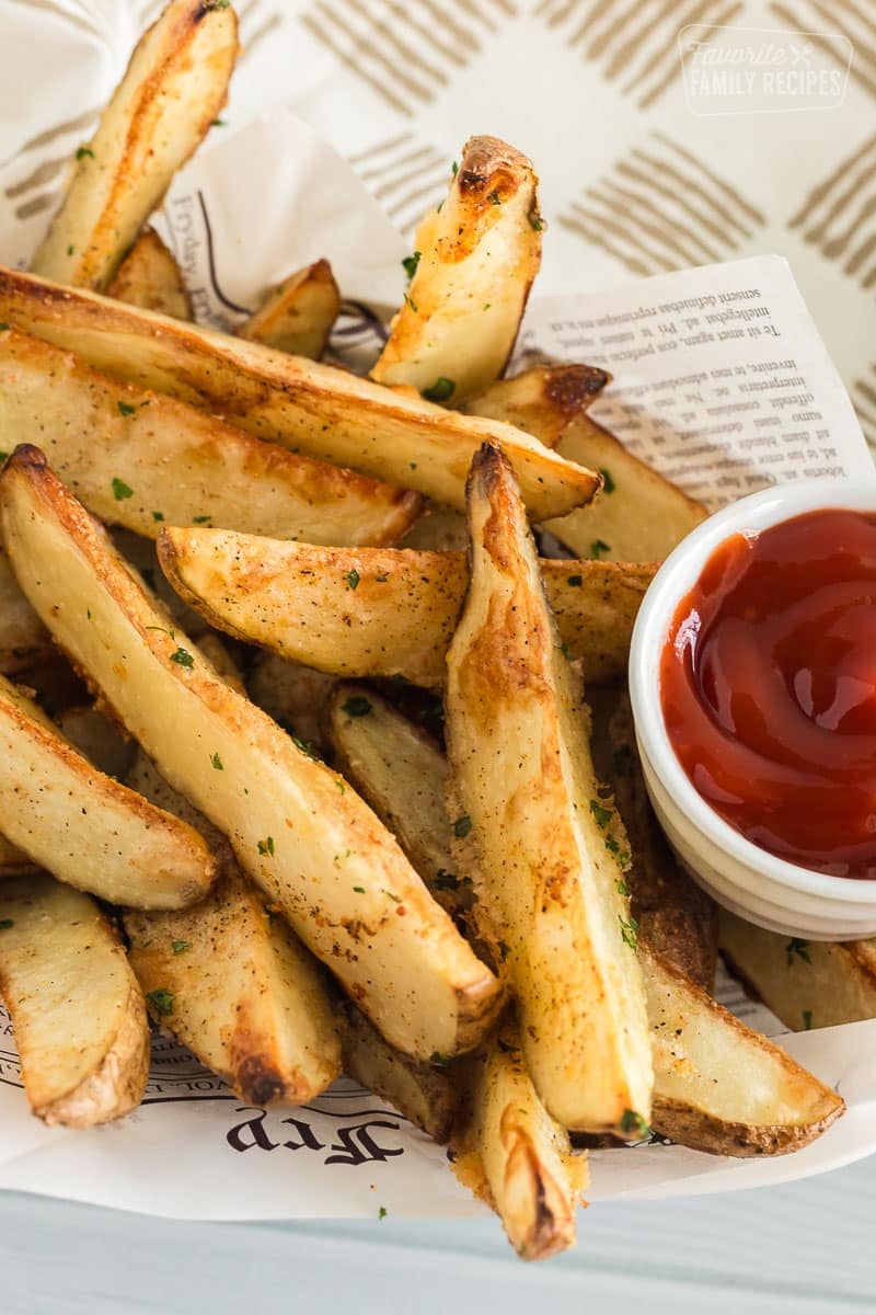 Baked potato wedges in a fry basket with ketchup