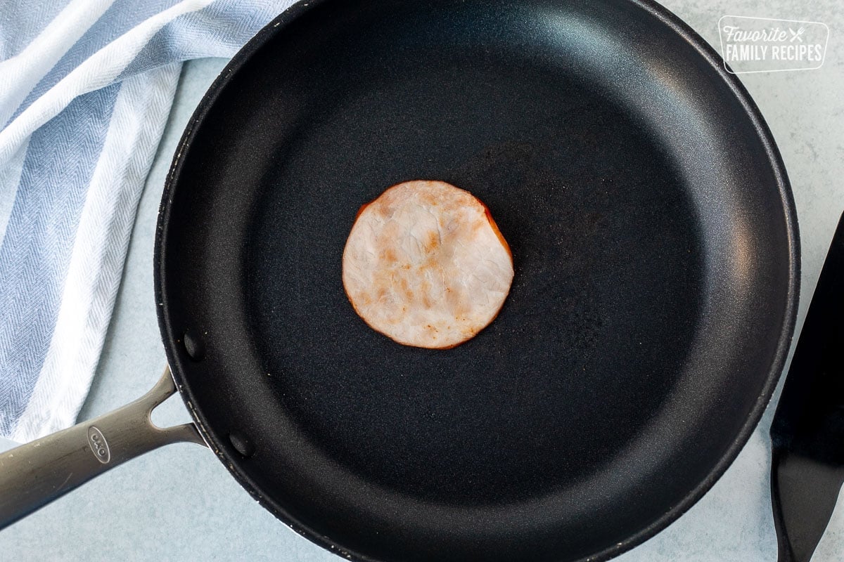 Skillet with browned Canadian bacon.