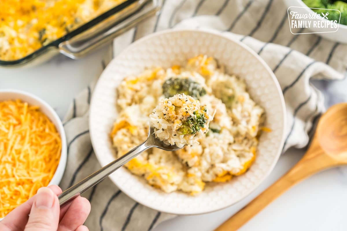 Chicken rice broccoli casserole in a bowl with a spoon taking out a bite.