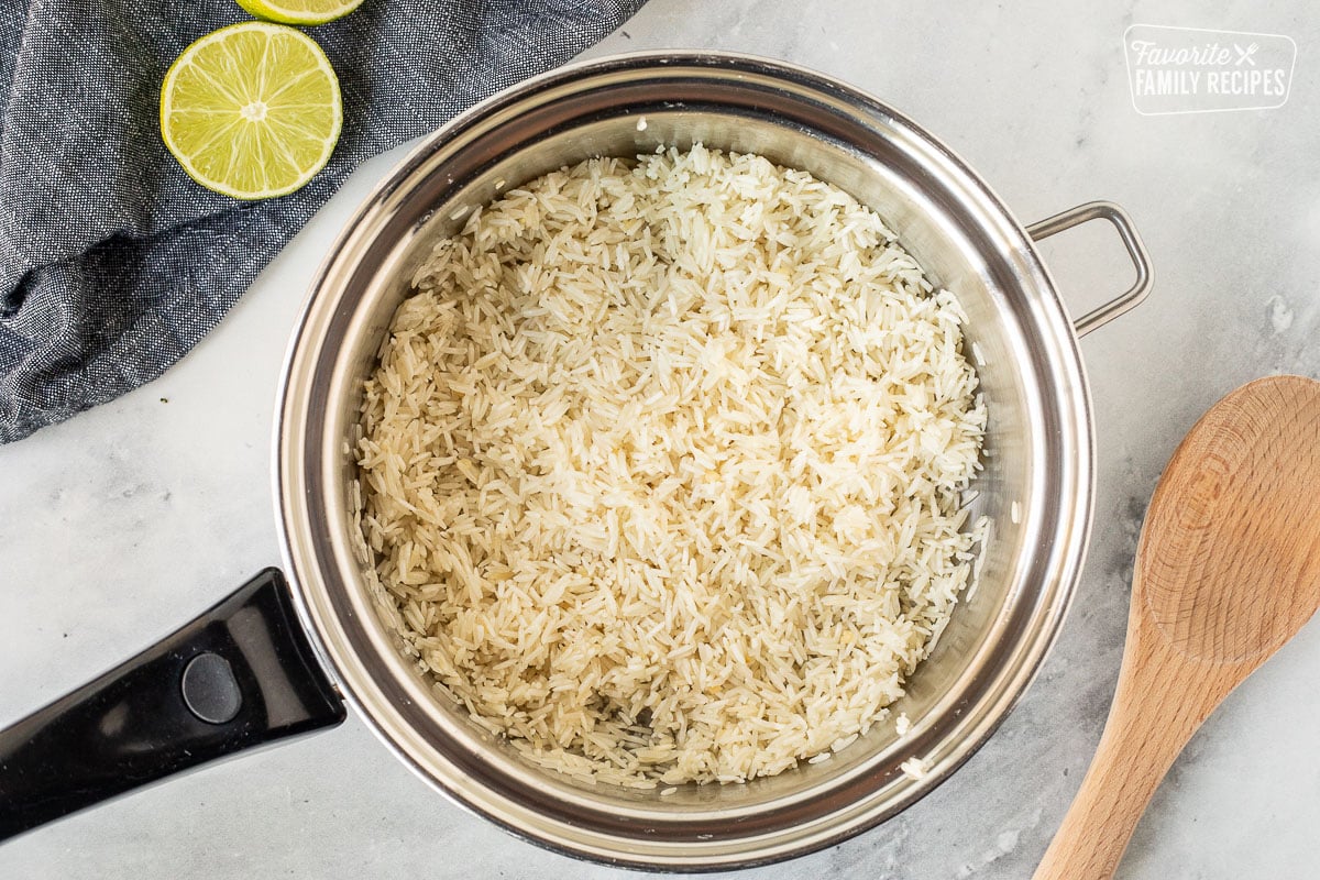 Saucepan of sauté rice. Wooden spoon on the side.