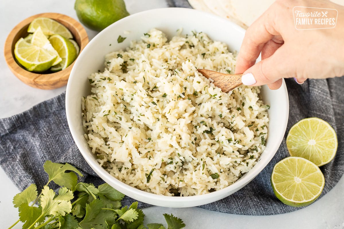 Scooping Chipotle Rice with a wooden spoon.