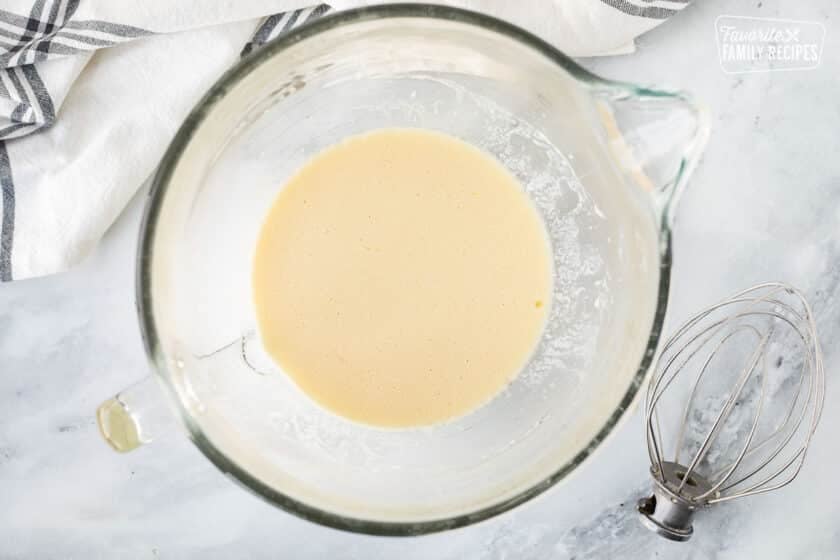 Mixing bowl with wet ingredients combined. Whisk attachment on the side.