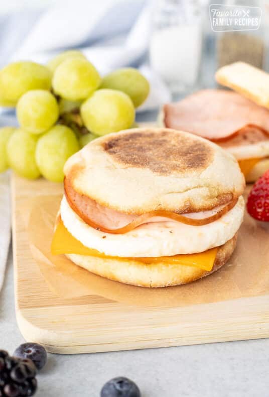Egg McMuffin on a cutting board with egg, cheese and Canadian bacon.