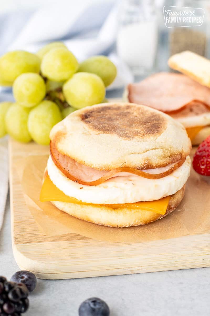 Egg McMuffin on a cutting board with egg, cheese and Canadian bacon.