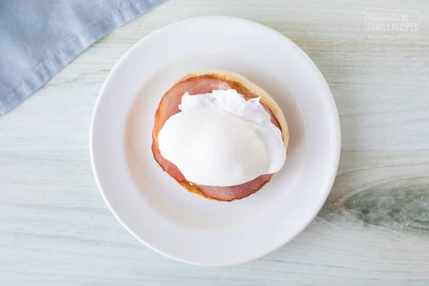 An english muffin, Canadian bacon and an egg stacked for a eggs benedict