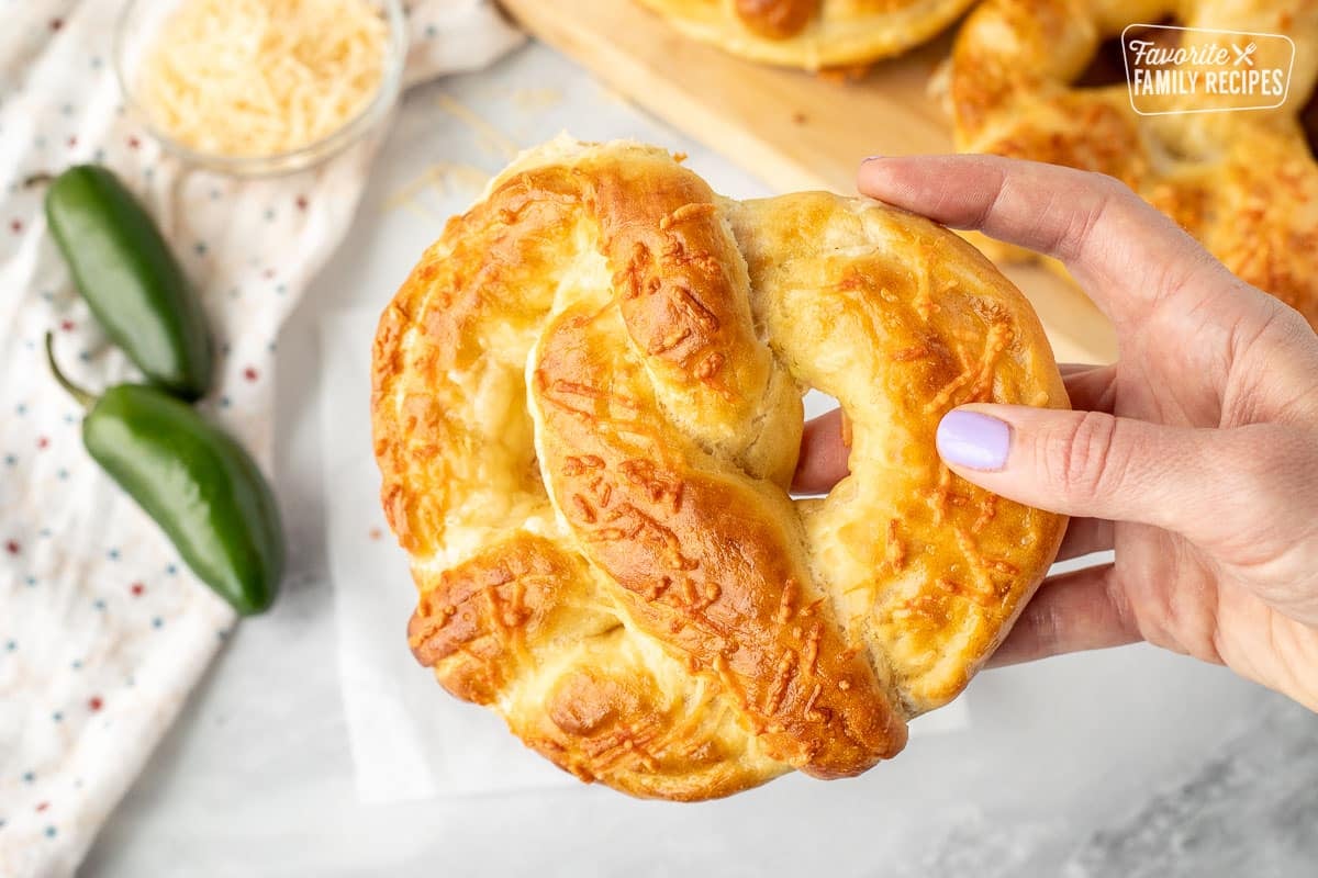 Hand holding a Jalapeno Cheese Stuffed Pretzel.