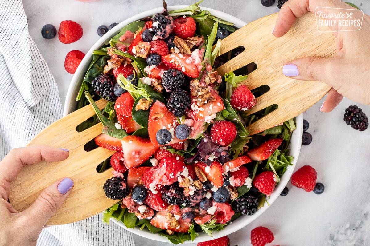 Nuts About Berries Salad with salad tongs.