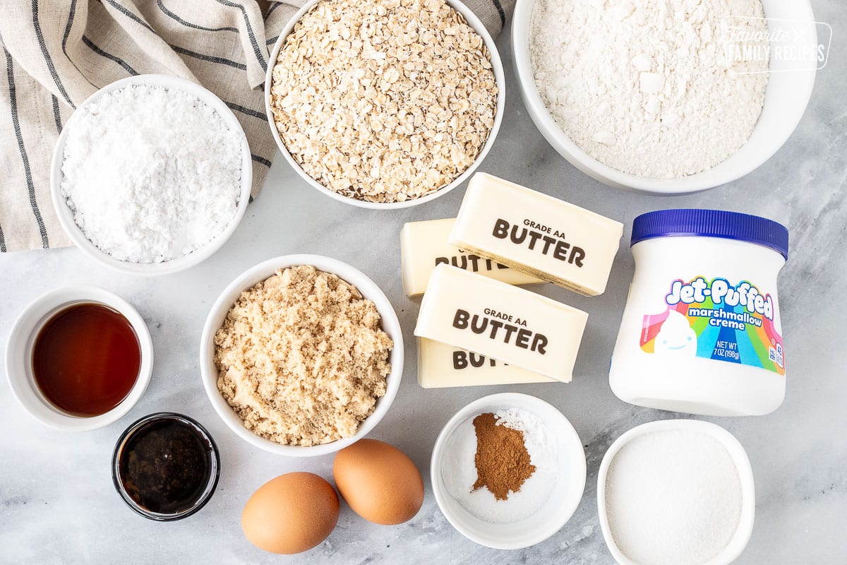 Ingredients to make Oatmeal Cream Pies including flour, oatmeal, powdered sugar, sugar, brown sugar, vanilla, molasses, eggs, butter, spices and marshmallow fluff.