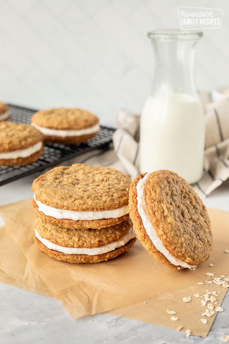 Three Oatmeal cream pies stacked next to milk.