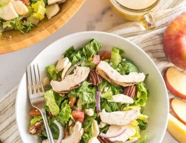 Panera Bread Fuji Apple Salad in a bowl topped with chicken