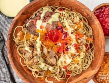 A copycat Satu'li bowl recipe in a wooden bowl next to cups of boba balls with dressing over the top