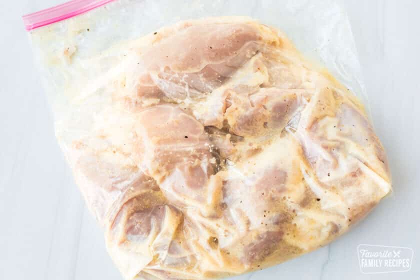 Chicken marinating in a clear Ziplock bag