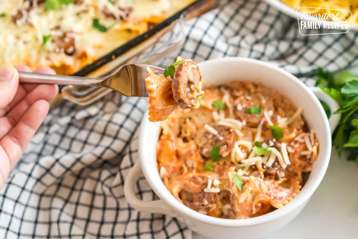 A bowl of Sausage Pasta Bake with a fork taking a bite.