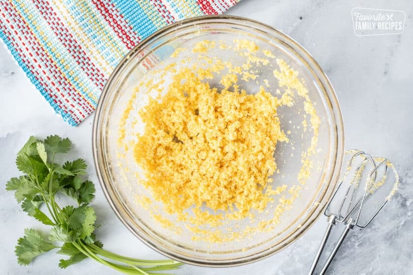 Bowl of blended corn meal and butter. Whisks on the side.