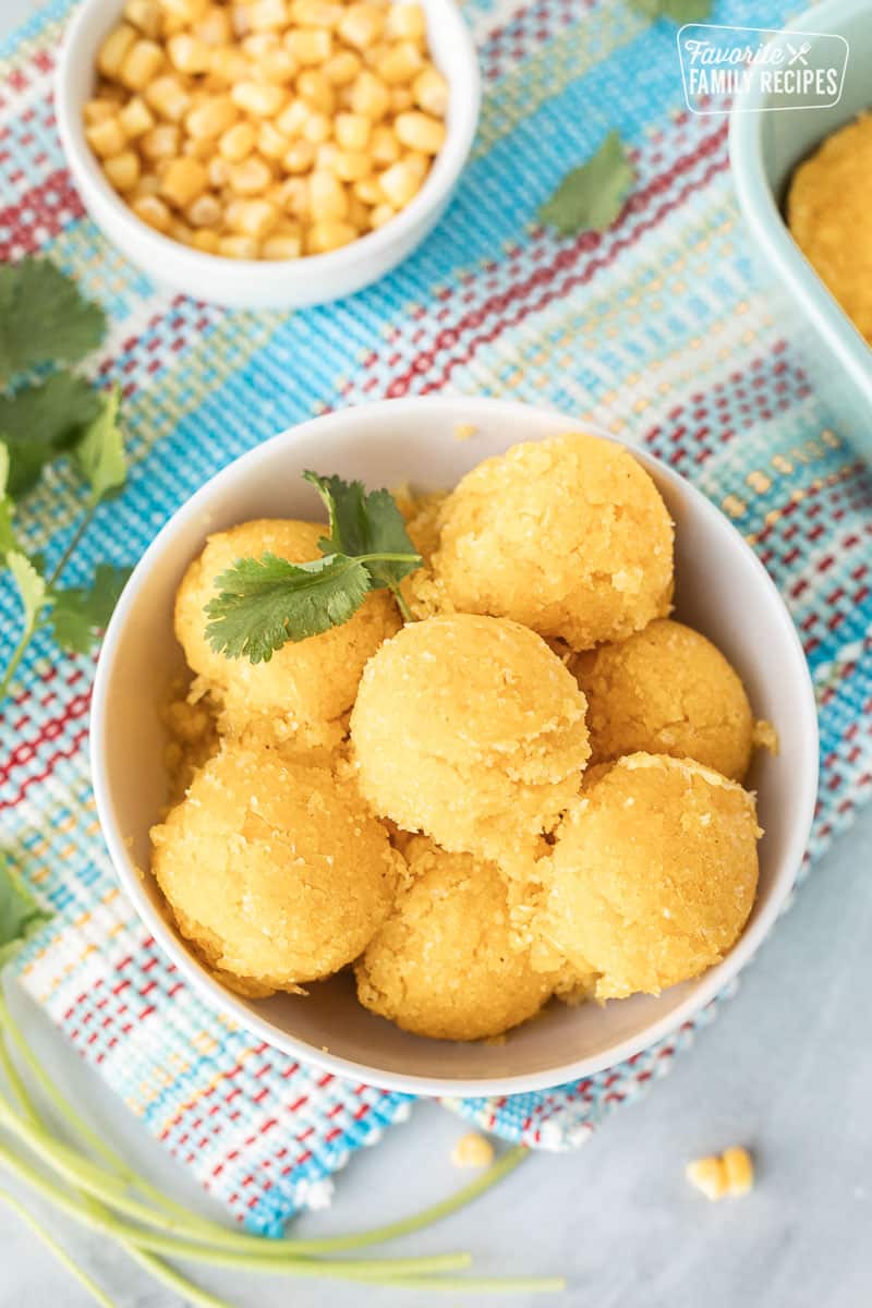Bowl of Sweet Corn Cakes Tomalitos rounded in balls. Garnished with cilantro.