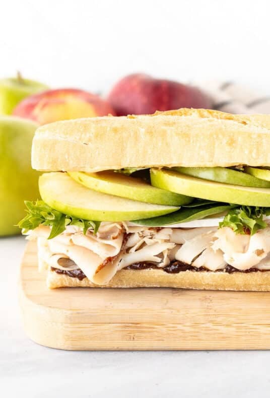 Turkey sandwich with fig butter, brie cheese, greens, apples and dijon mustard on a French baguette.