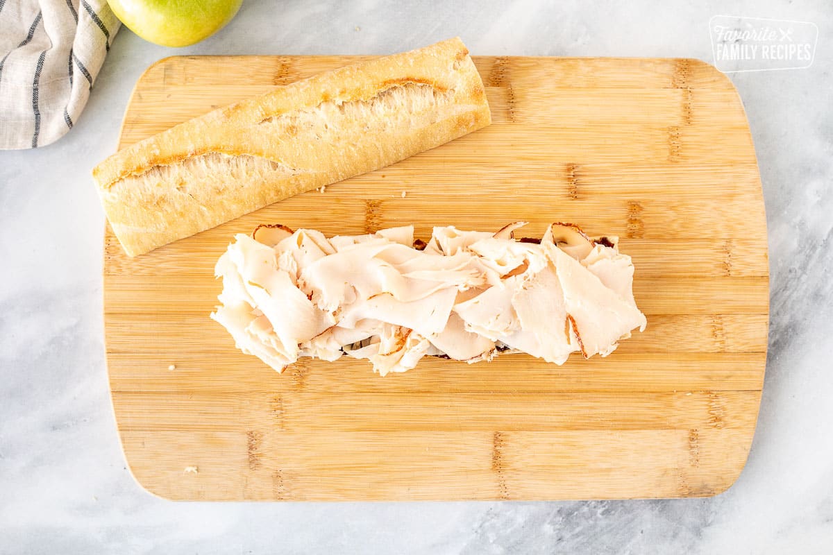 Placing turkey deli meat on top of fig butter spread.