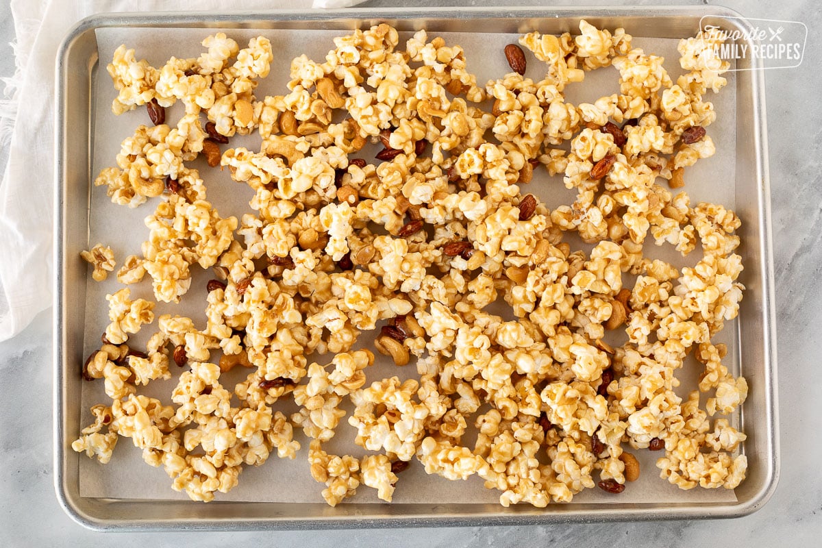 Sheet pan with unbaked caramel nut popcorn mixture.