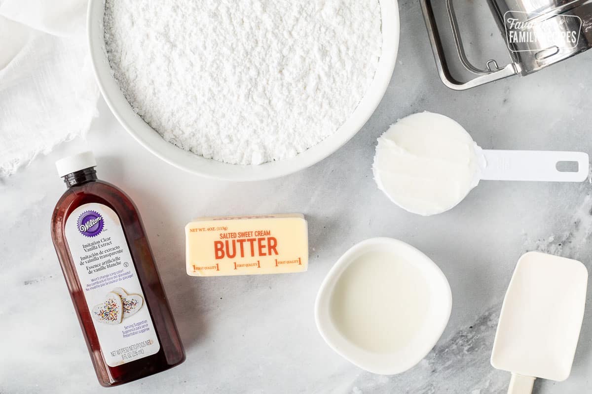 Ingredients to make Vanilla Buttercream Frosting including powdered sugar, butter, milk, shortening and clear vanilla.