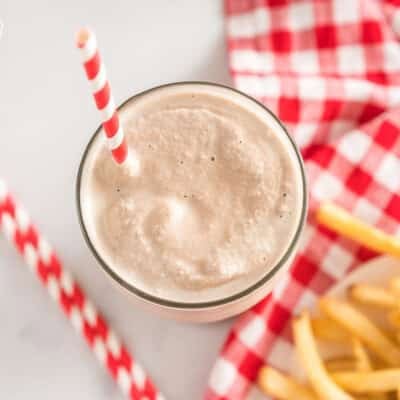 Wendy's frosty in a glass cup with a striped straw