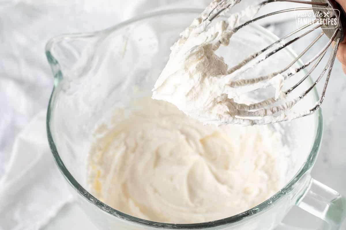 Whisk attachment holding up Vanilla Buttercream Frosting.
