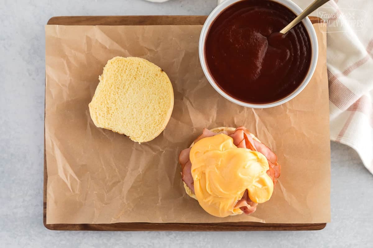 Onion bun with arby's sauce, ham, and cheddar cheese sauce ready to be put together