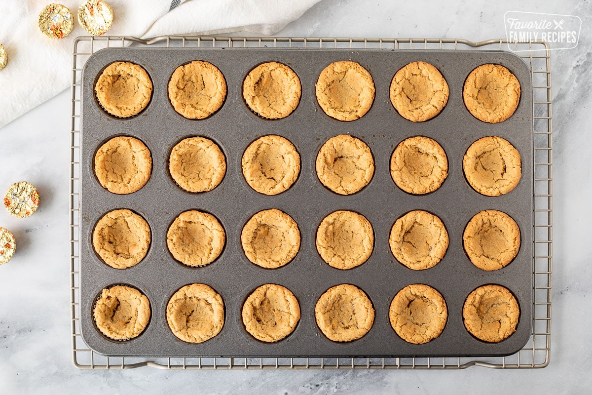Miniature muffin pan with baked peanut butter cookies.
