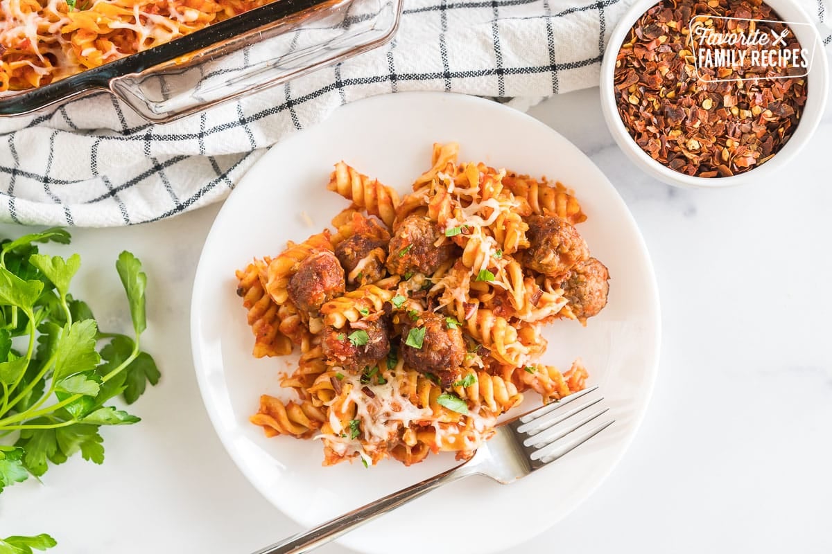 Baked Rotini on a plate garnished with cheese and parsley