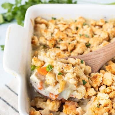 Wooden spoon scooping Chicken Pot Pie Casserole.