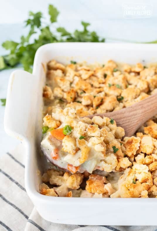 Wooden spoon scooping Chicken Pot Pie Casserole.