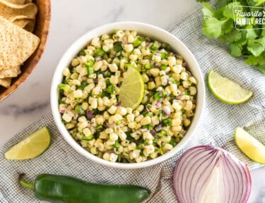 A bowl of Chipotle Corn Salsa topped with a lime wedge