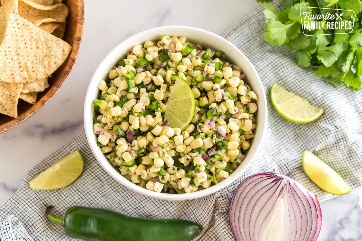 A bowl of Chipotle Corn Salsa topped with a lime wedge