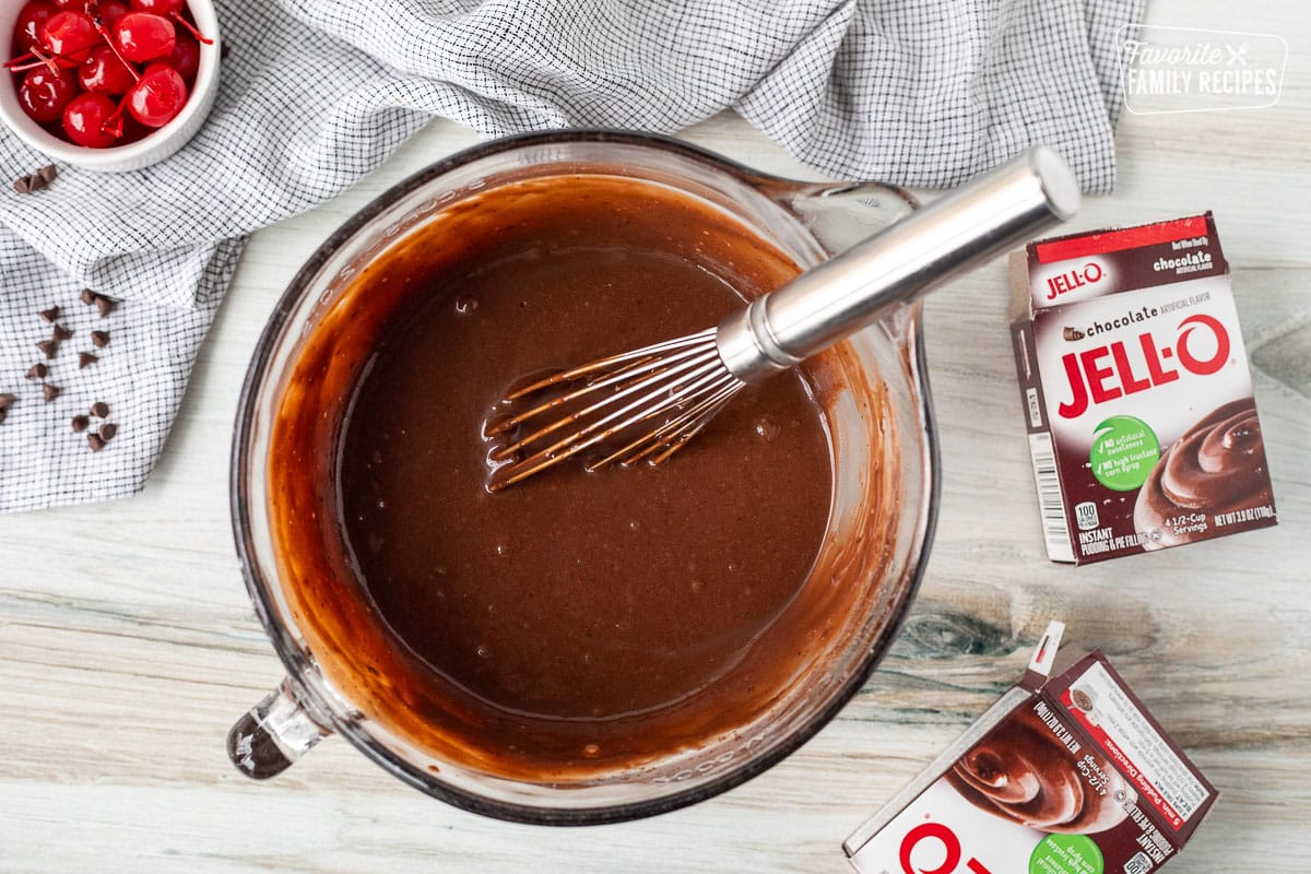 Mixing bowl with mixed chocolate pudding with whisk.