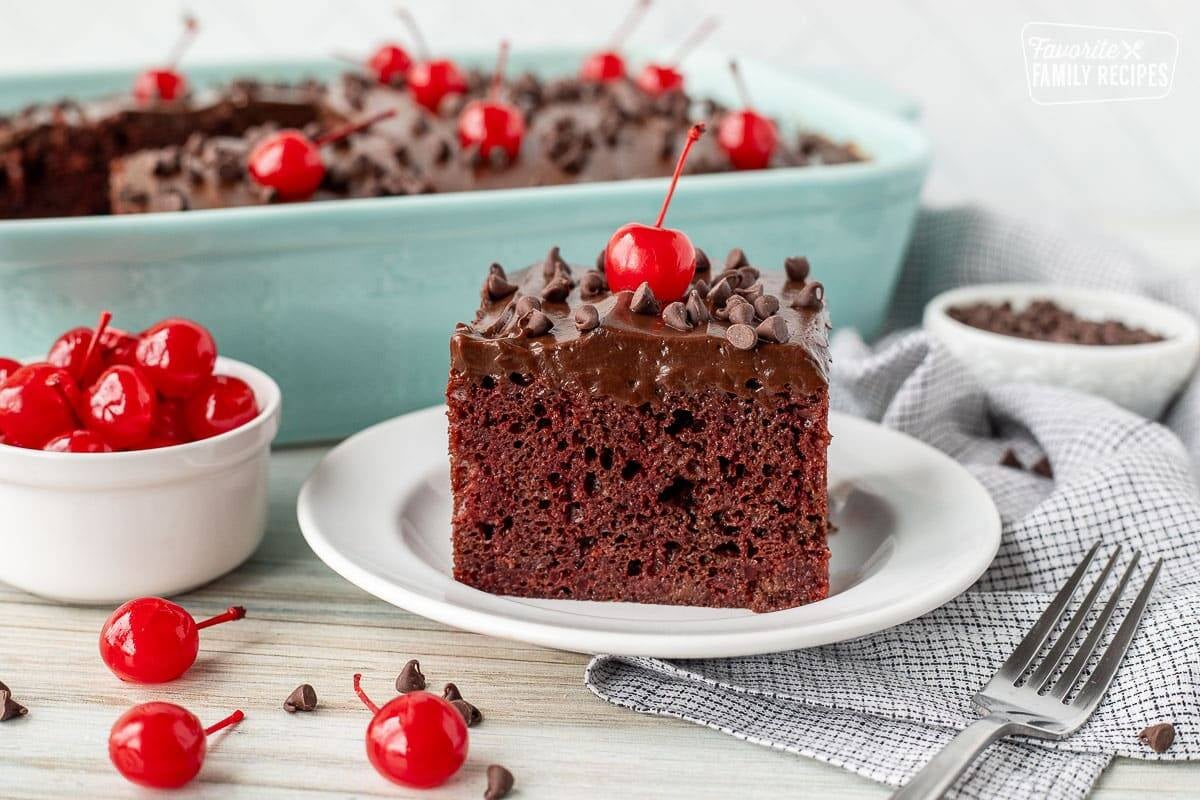 Cut slice of Chocolate Cherry Cake with chocolate chips and maraschino cherries.