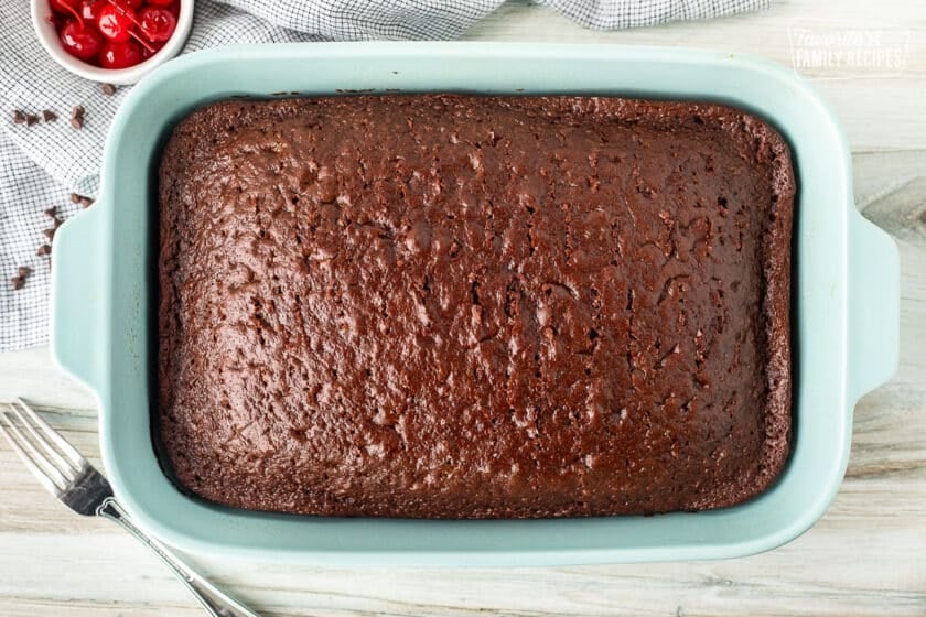 Poked holes in a baked chocolate cake with a fork.