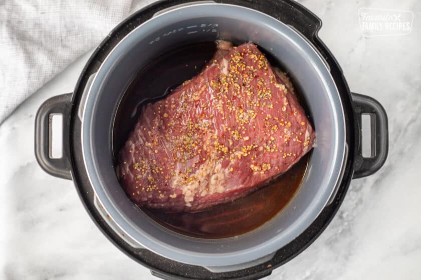 Instant Pot with beef broth, Corned Beef Brisket with garlic and seasoning packet.