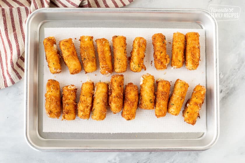 Homemade Mozzarella Sticks on a cookie sheet lined with paper towels.