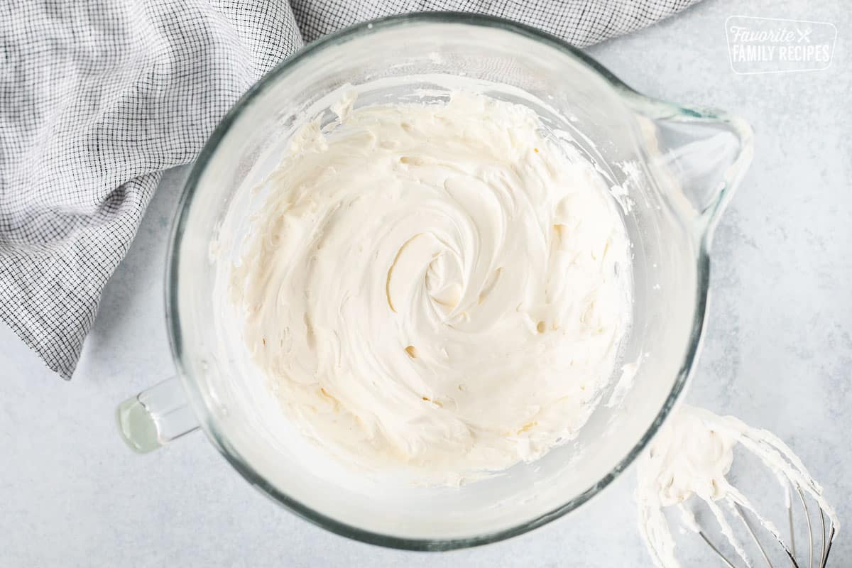 Mixing bowl with Cool Whip cream cheese frosting. Mixing whisk on the side.