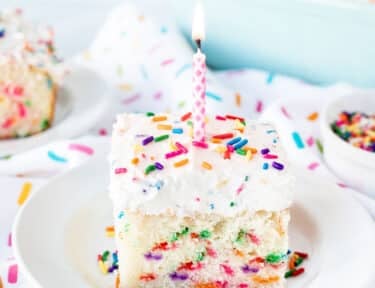 Birthday candle on top of a slice of Funfetti Cake.