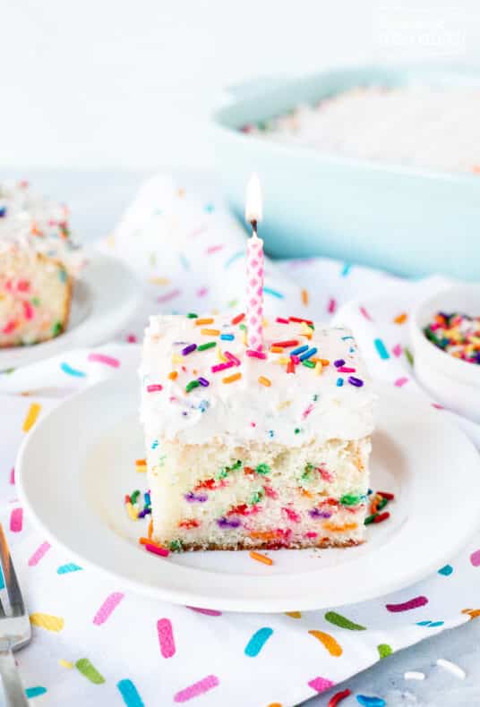 Birthday candle on top of a slice of Funfetti Cake.