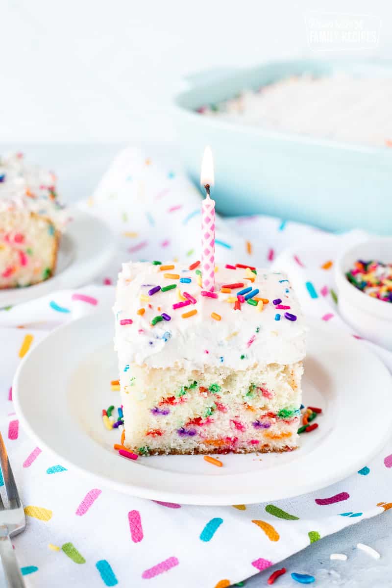Birthday candle on top of a slice of Funfetti Cake.